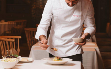 Gourmet cuisine served by the chef at Castilla Termal Monasterio de Valbuena Chef presenting a beautifully plated gourmet dish at Castilla Termal Monasterio de Valbuena