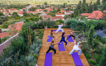 Guests taking part in a peaceful outdoor yoga session at Euphoria Retreat in Greece, surrounded by natural beauty and tranquillity.