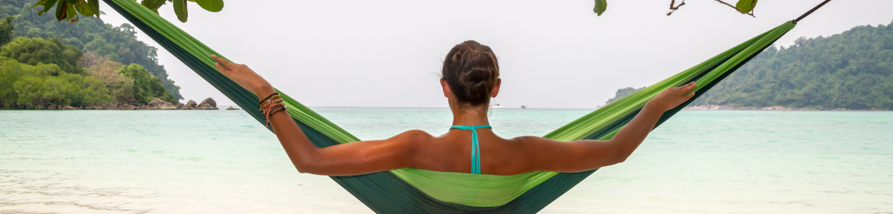 Woman reading a book by the beach at sunset during a digital detox retreat
