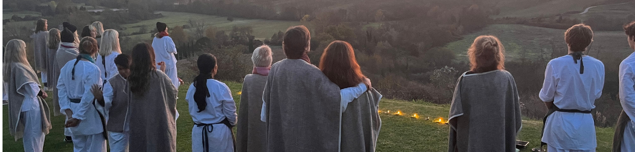 Group of people in a circle stretching outdoors surrounded by greenery