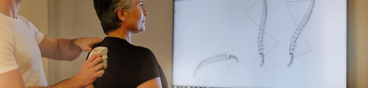 Mature woman receiving physiotherapy results from a male consultant at a retreat