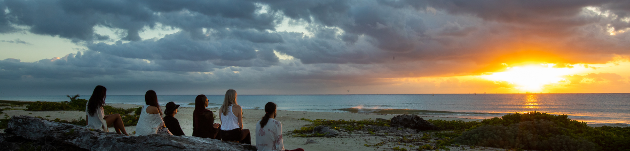 Holistic Retreat – Meditation on the beach Group of people sitting on the beach watching the sunset at a holistic retreat in Mexico