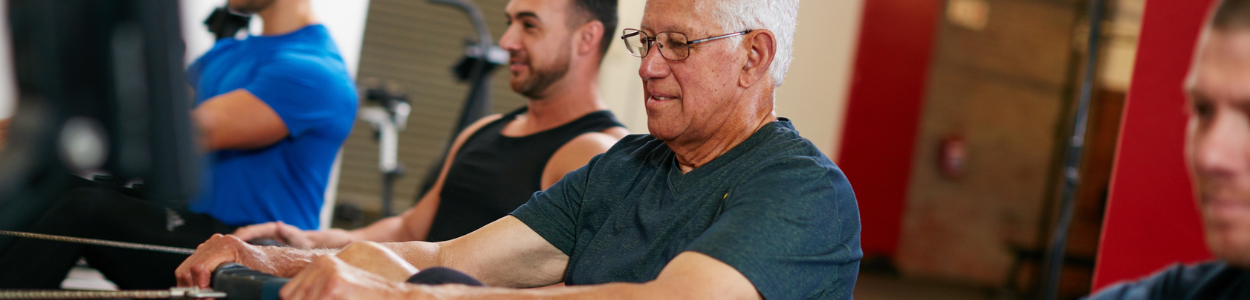 Mixed ages of men cycling on a cycling machine in a gym on a fitness retreat