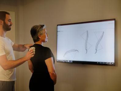 Mature woman receiving physiotherapy results from a male consultant at a retreat