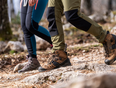 Man and woman hiking among leafy hills