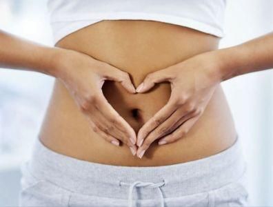 Woman placing her hands over her stomach forming a heart shape during a gut health retreat