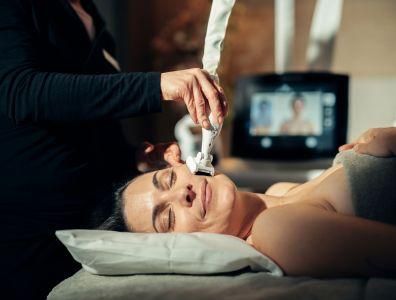 Woman receiving a non-invasive facial treatment at an aesthetics retreat