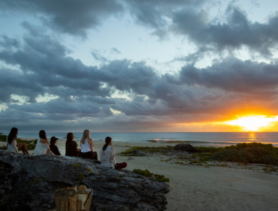 Holistic Retreat – Meditation on the beach Group of people sitting on the beach watching the sunset at a holistic retreat in Mexico