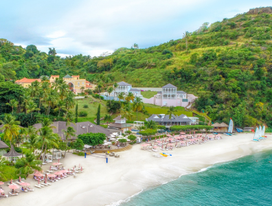 Spa Retreat in Caribbean – Yoga by the Sea Group yoga session on a platform by the sea with palm trees in the Caribbean
