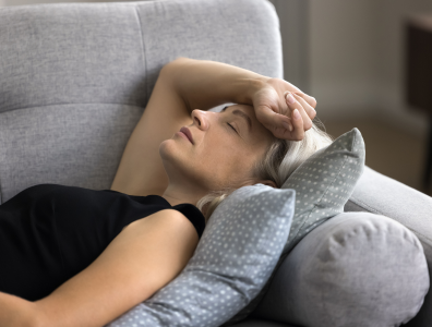 Burnout Recovery – Woman Finding Calm and peace Woman laying on a sofa with her hand over her head resting