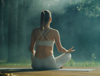 Two women practising yoga on mats overlooking the sea 