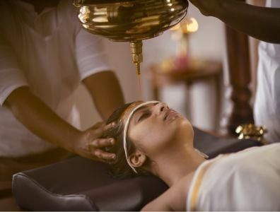 Woman receiving a traditional Ayurveda treatment at a wellness retreat
