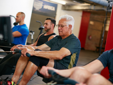 Mixed ages of men cycling on a cycling machine in a gym on a fitness retreat