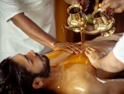 Man receiving a traditional Panchakarma oil treatment at a wellness retreat