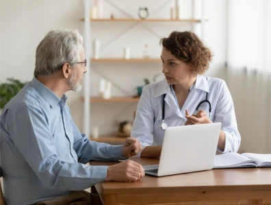 Guest sits with female consultant as she discusses medical results in a white room