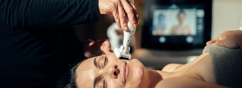 Woman receiving a non-invasive facial treatment at an aesthetics retreat