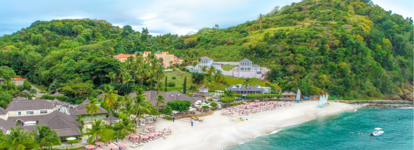 Spa Retreat in Caribbean – Yoga by the Sea Group yoga session on a platform by the sea with palm trees in the Caribbean