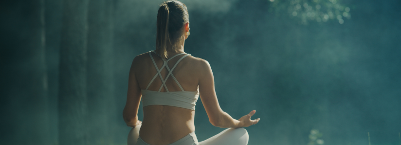 Two women practising yoga on mats overlooking the sea 