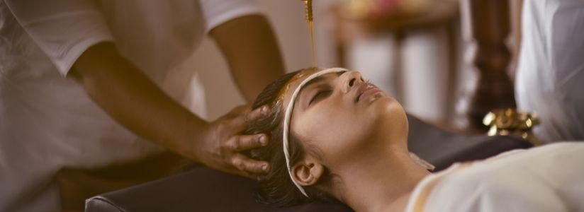Woman receiving a traditional Ayurveda treatment at a wellness retreat