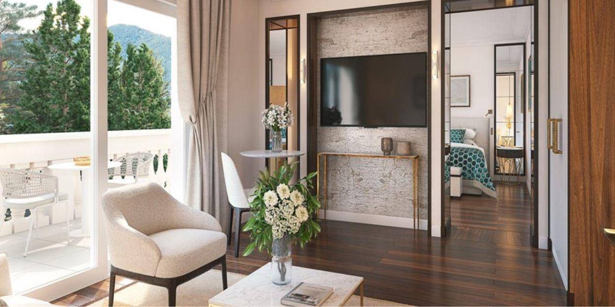 Grand hotel suite located on upper floors with balcony overlooking the park, sitting area with TV leading to the main bedroom