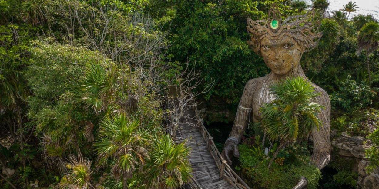 Artwork at Palmaïa – The House of AïA Giant wood-carved sculpture among mangroves, depicting a woman with a crown and holding greenery in her arms