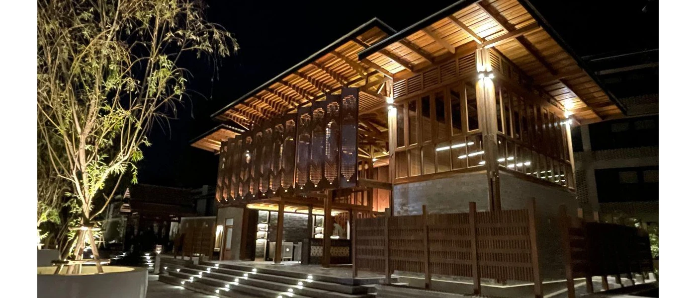 Traditional teak villa with stepped access and column lighting lit up at night