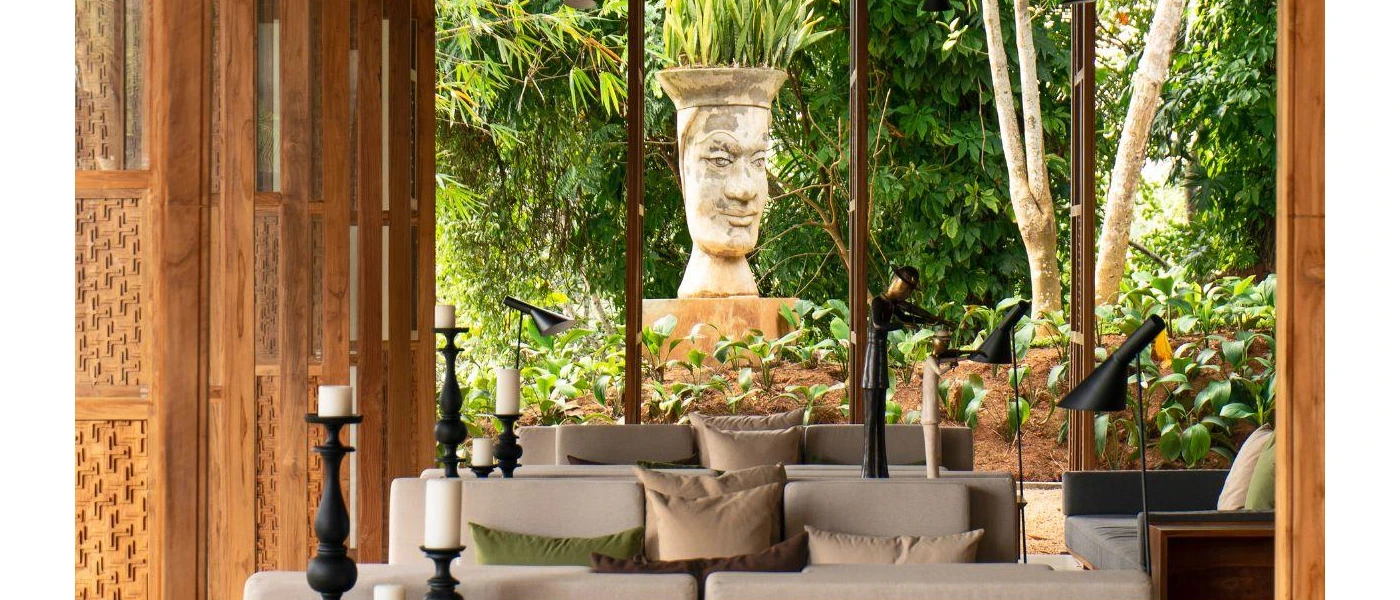 Cushioned sofas surrounded by black candlesticks in a wooden seating area