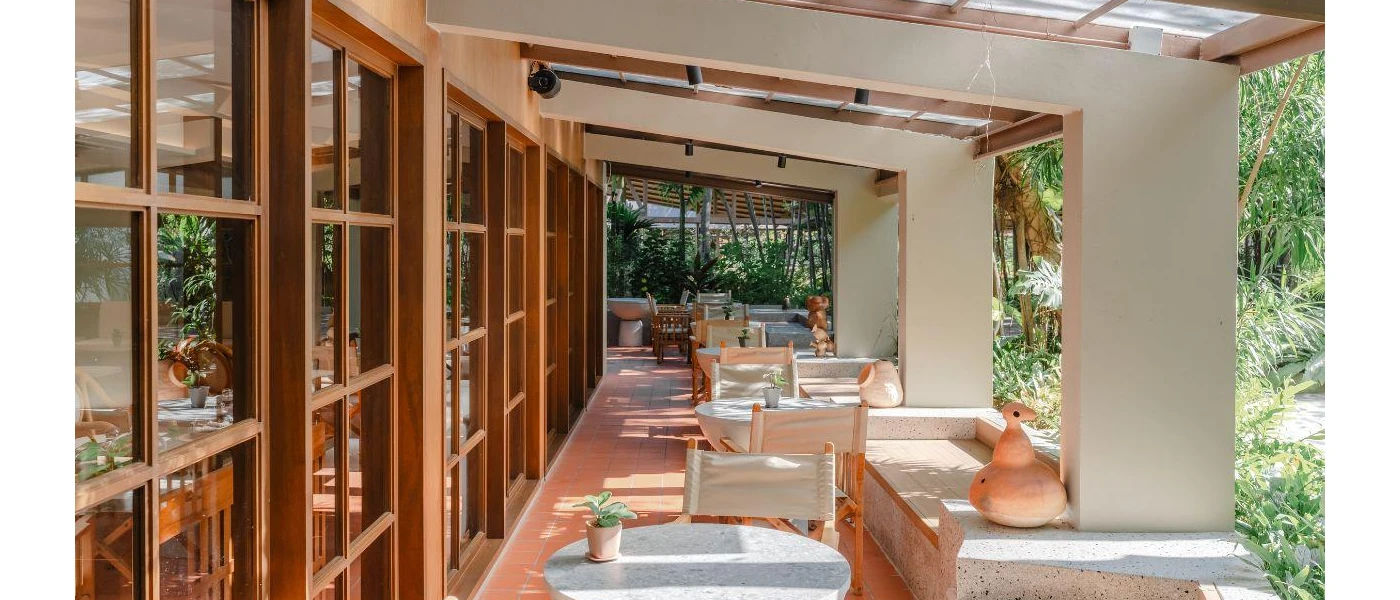 Covered outdoor terrace with white tables and chairs and terracotta pots