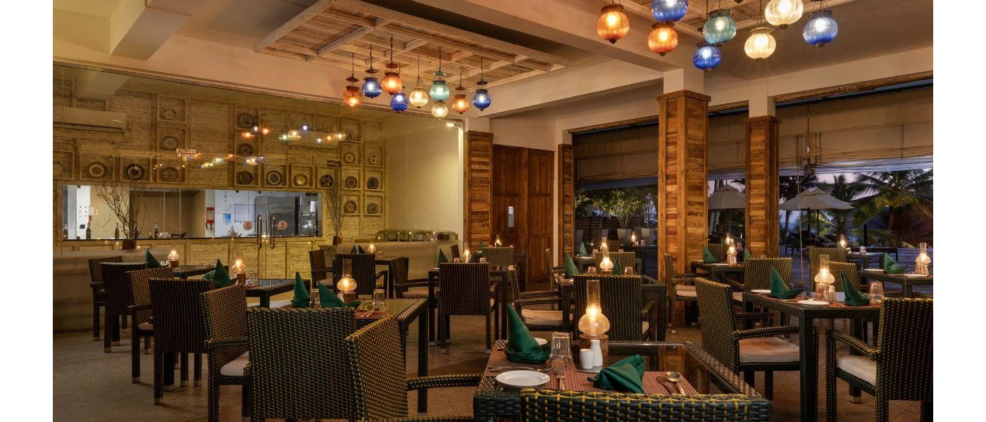 Restaurant with hanging coloured lanterns, dark-wood rattan tables and chairs and wooden pillars