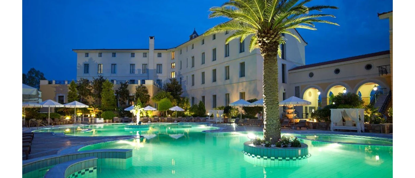 Swimming pool with palm islands at night lit by underwater lights