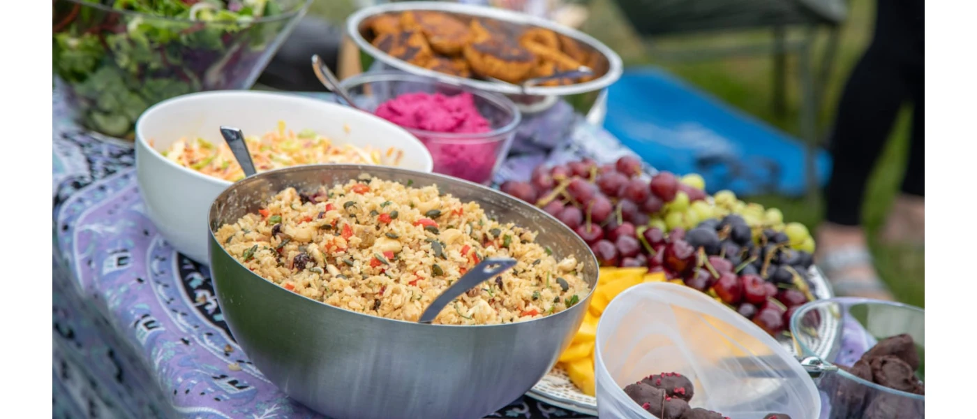 A selection of food in large bowls next to a fruit platter