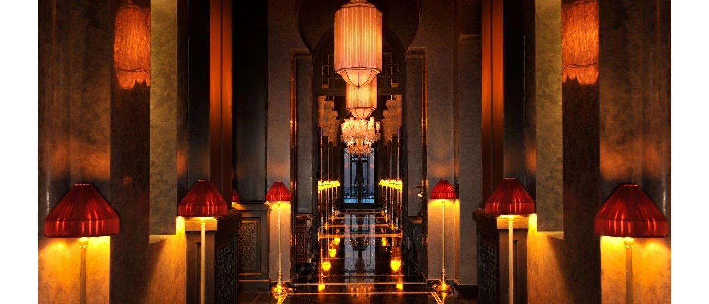 Softly lit corridor with dark pillars and hanging lanterns