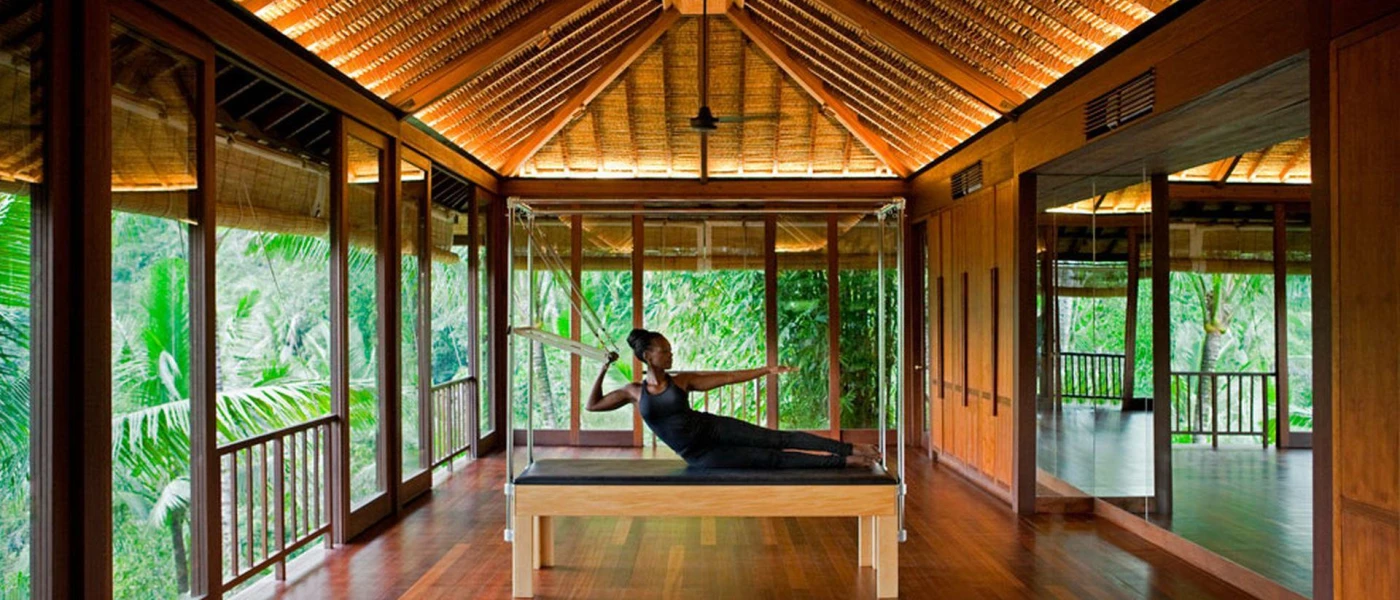 Woman in black active wear on a reformer Pilates machine