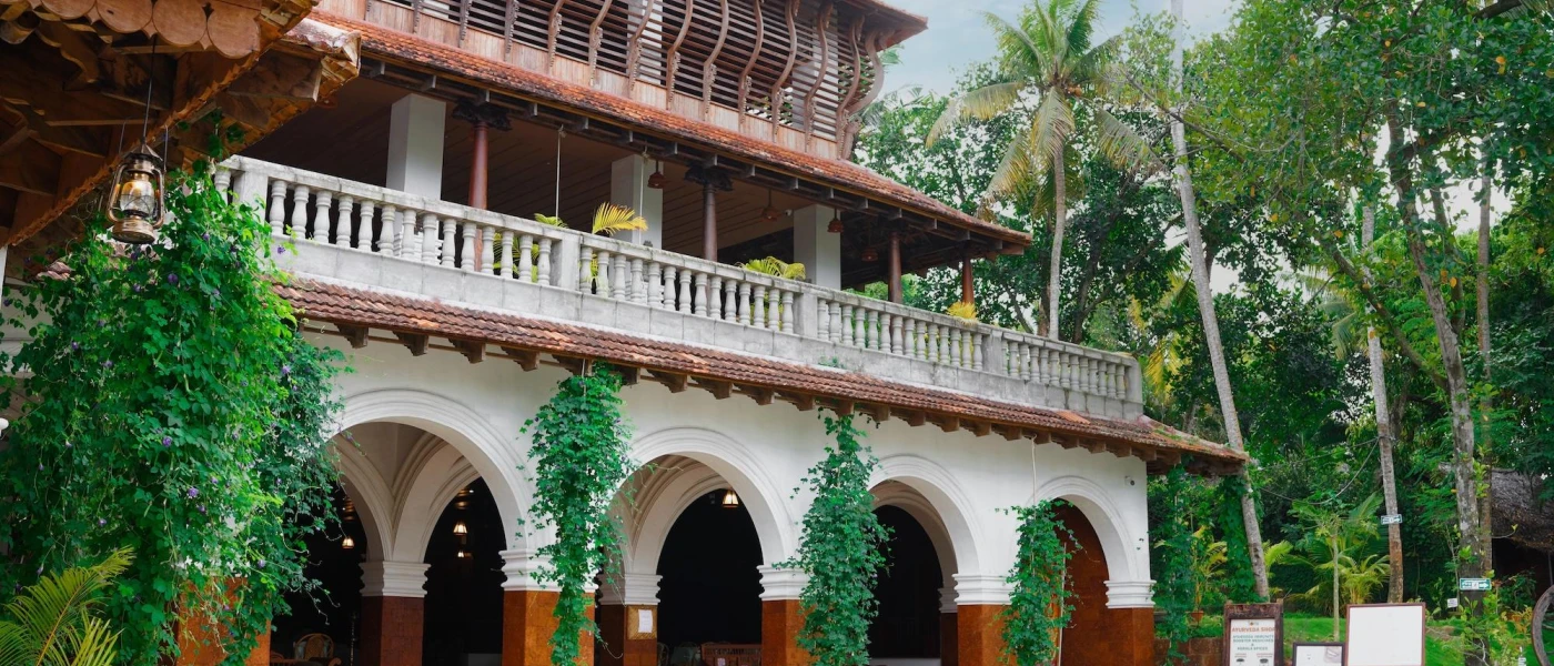 Traditional Indian architecture - sweeping archways, white balustrades, terracotta and white stone pillars and a terracotta tiled rooftop