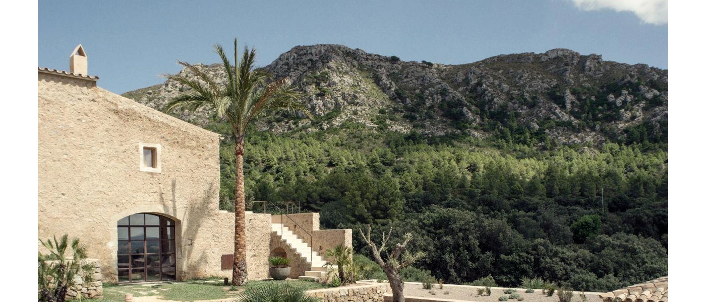 Traditional farmhouse among green hills and palm trees