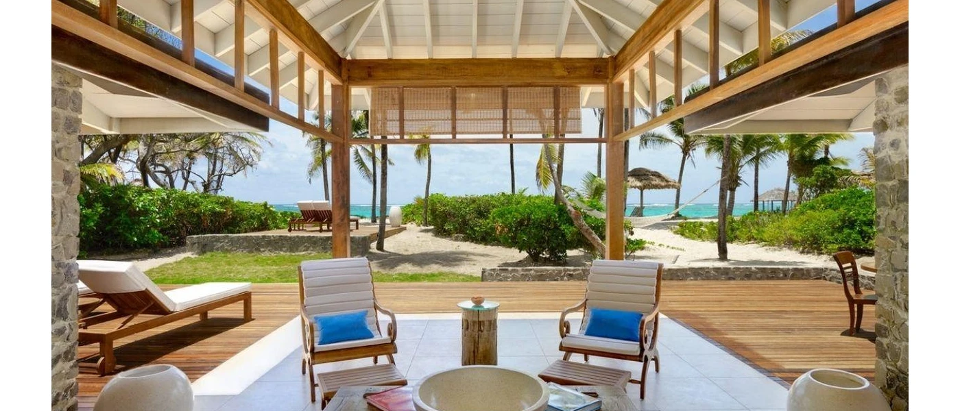Chairs and coffee table and a lounger in a terrace overlooking the beach
