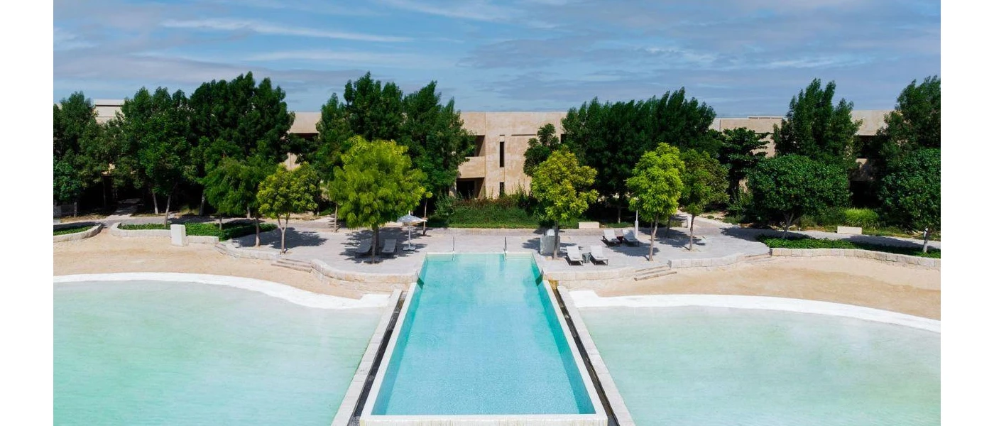 Swimming pool and man-made lagoon surrounded by greenery