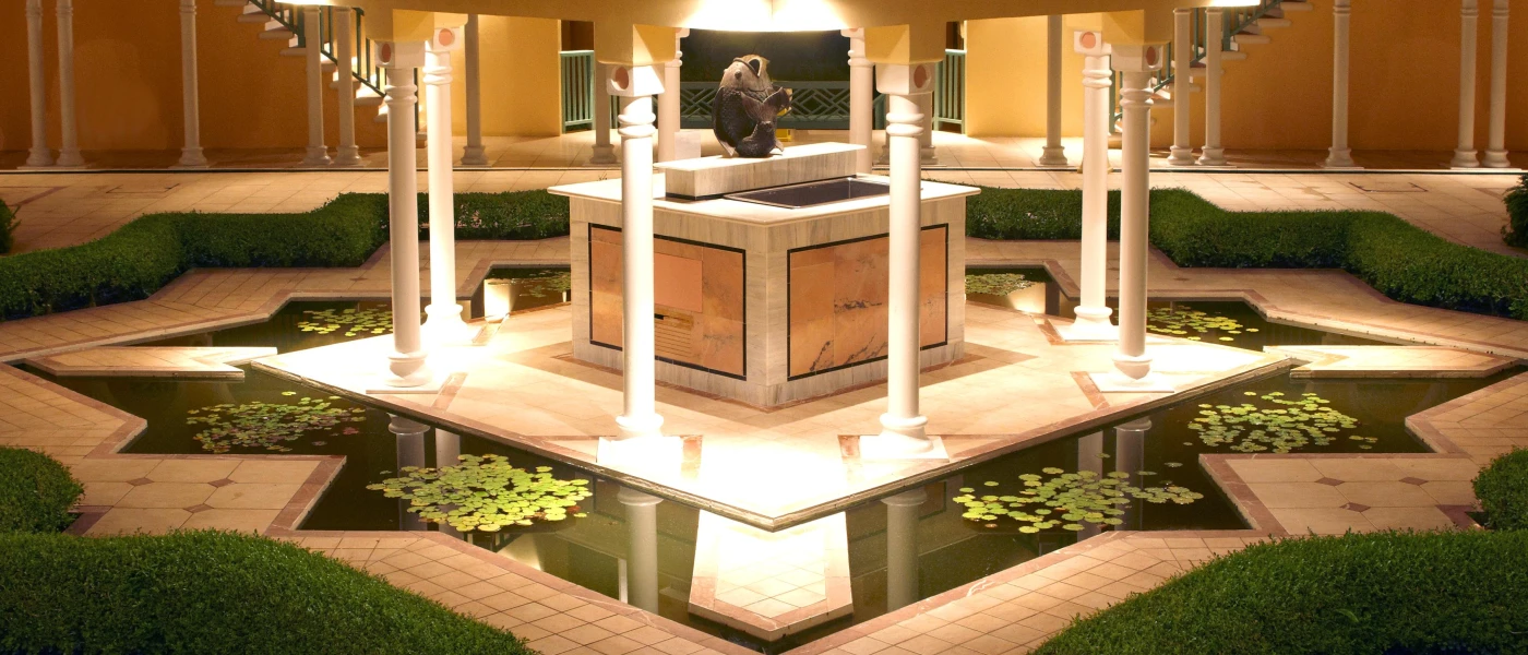 Illuminated water feature in a landscaped outdoor courtyard at night