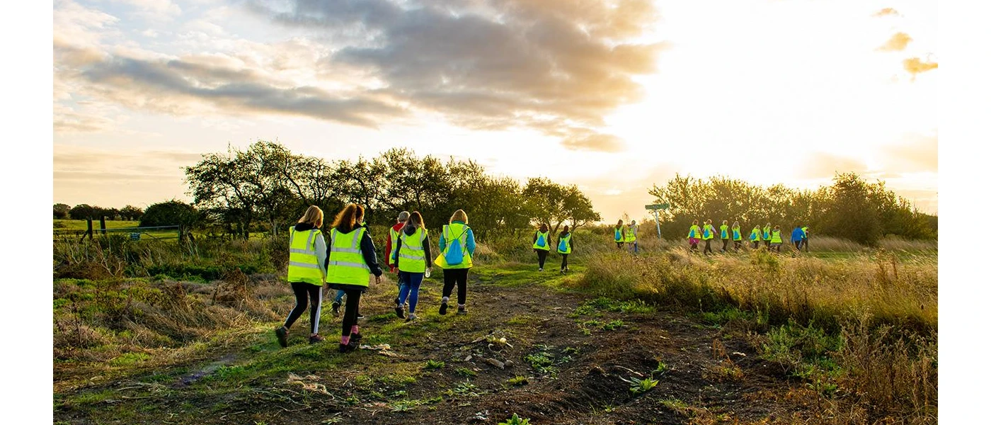 Group in high-visibility vests walking in the countryside