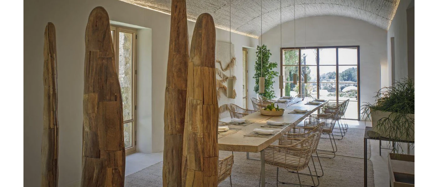Indoor table set up for dining in a airy restaurant with wooden sculptures