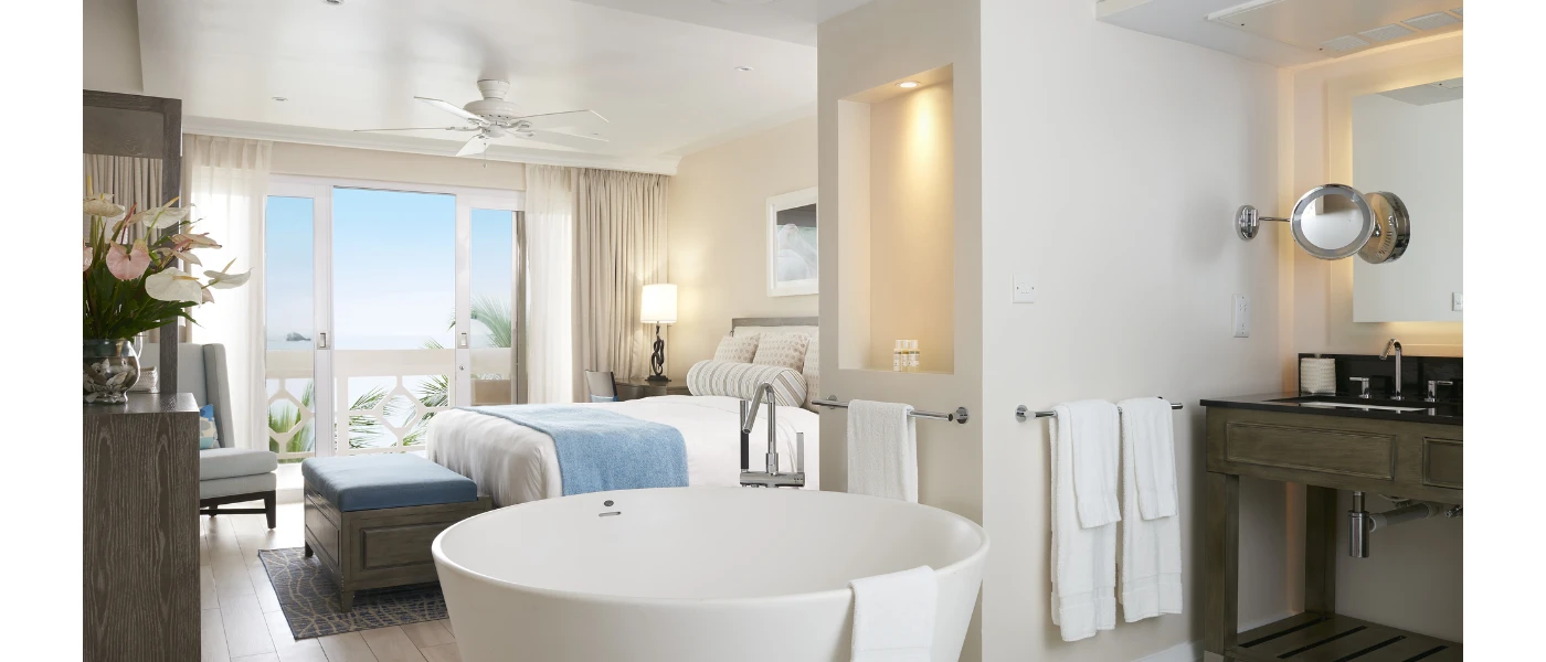 Stylish hotel suite with a standalone bathtub, neutral colour scheme and powder blue soft furnishings