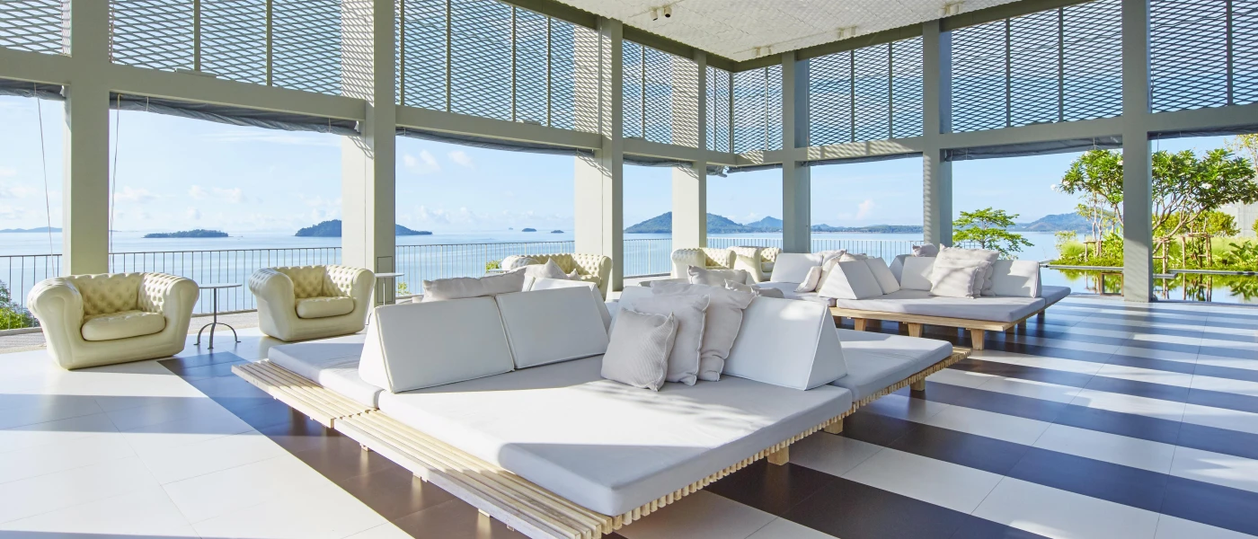 Sleek lobby area with supersized white sofas, a striped tiled floor and panoramic floor-to-ceiling windows