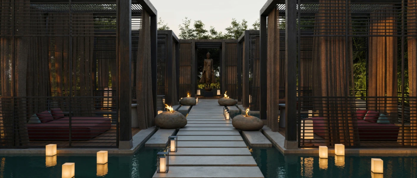 Stone walkway lined with lanterns with a Buddha statue at one end, and black cabin-style area with red daybeds