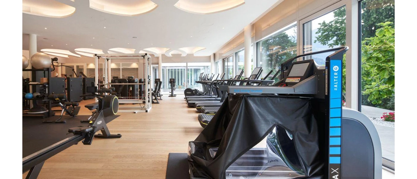 Gym with full-length windows, treadmills, a rowing machine, exercise balls and weights machines
