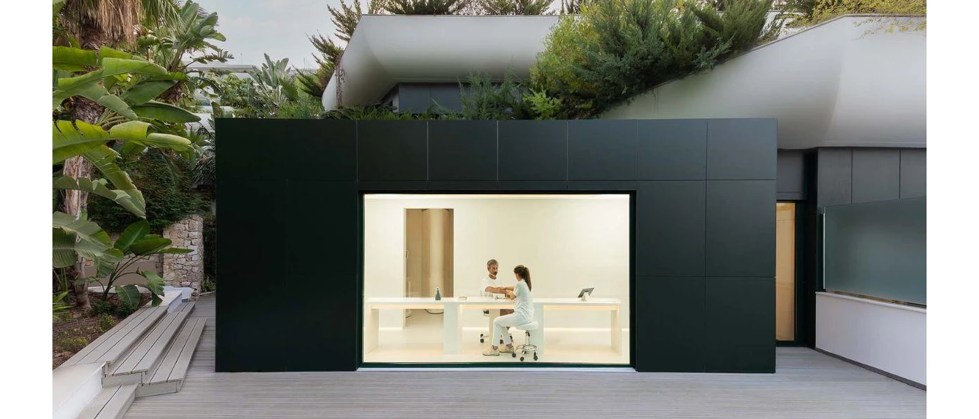 Futuristic looking wellness consultation room with a square black exterior and gleaming white interior