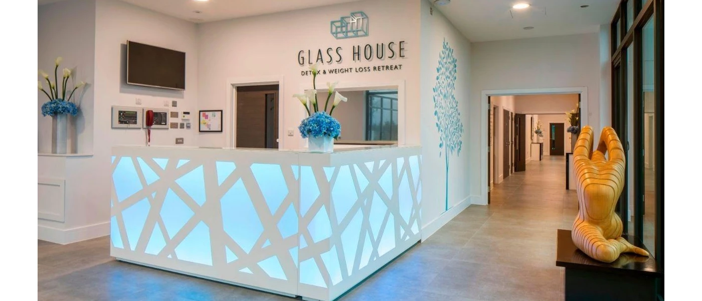 Modern reception desk with LED lighting and a Glass House sign