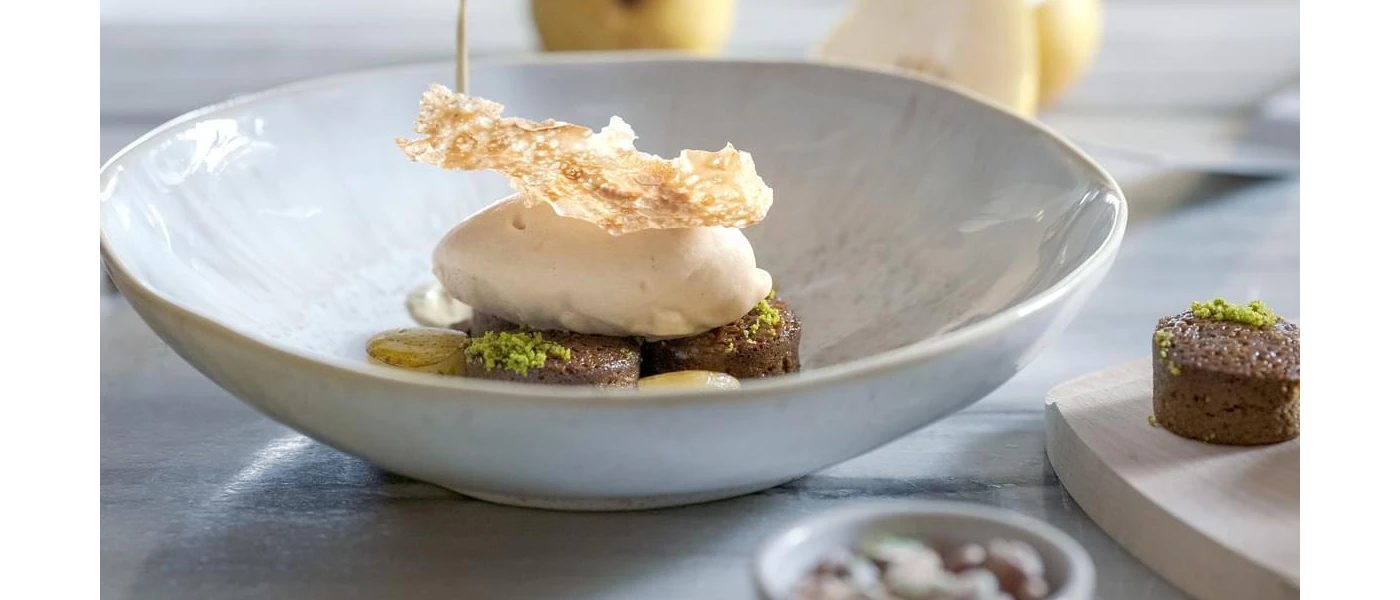 White bowl with a gourmet food stack of meat and potato