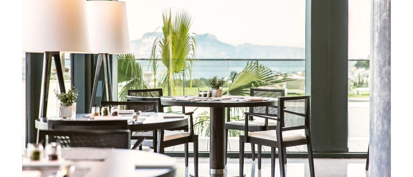 Airy restaurant with floor-to-ceiling windows and views of the mountains