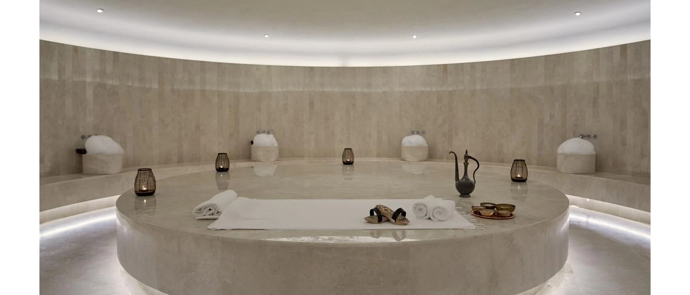 Wellness room dressed with marble, with a pouring jug and white towels 