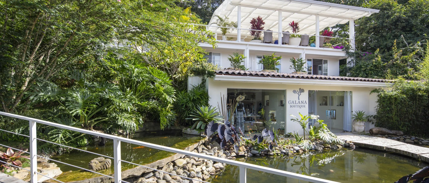 White building overlooking a pond surrounded by lush greenery at The Retreat Costa Rica  
